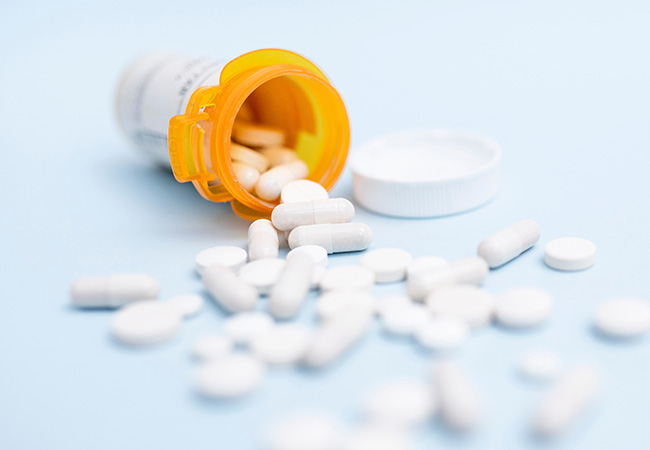Antibiotics coming out of a bottle.