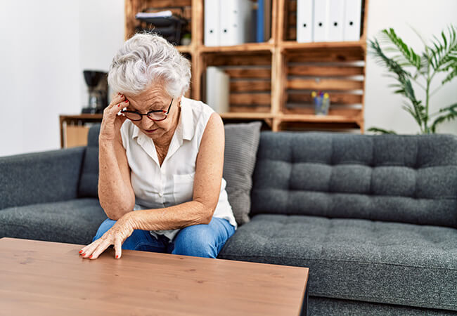 older woman holding head in hands